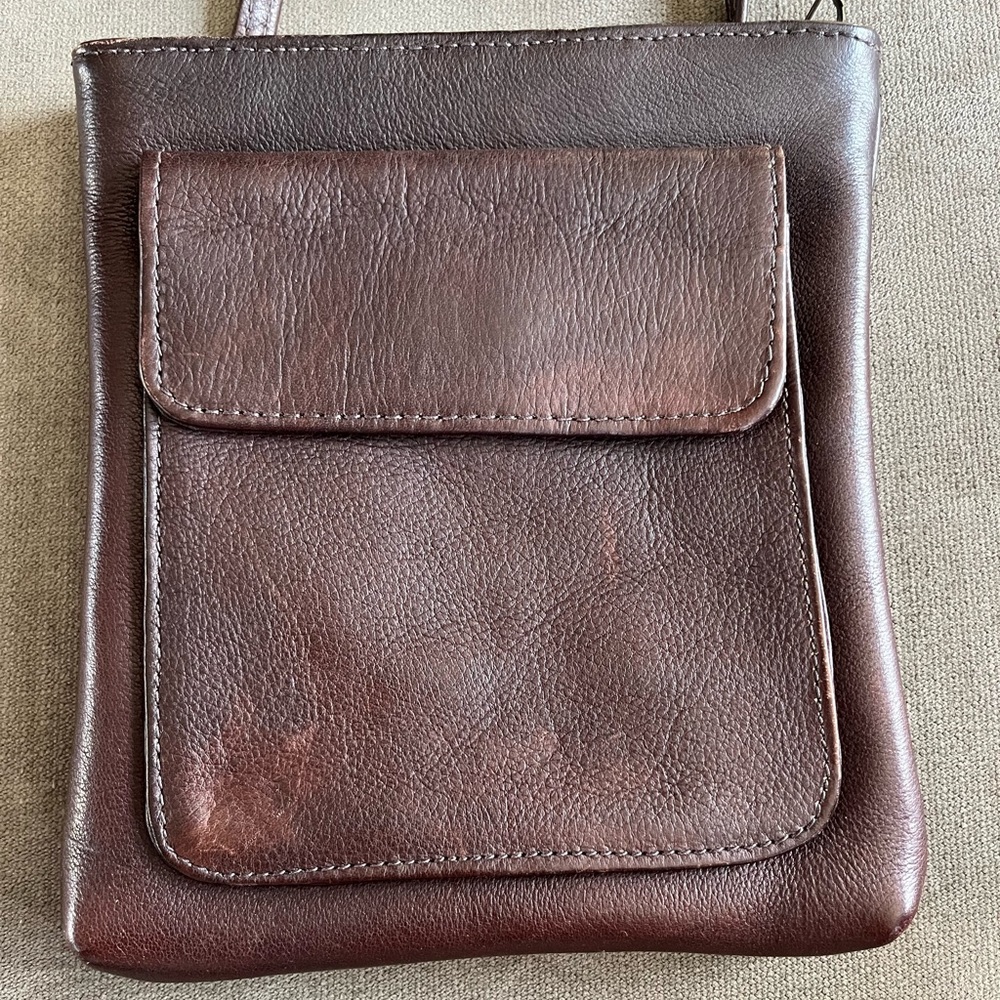 Brown leather crossbody. Zip top. Pockets on both sides. Zipped pocket inside.